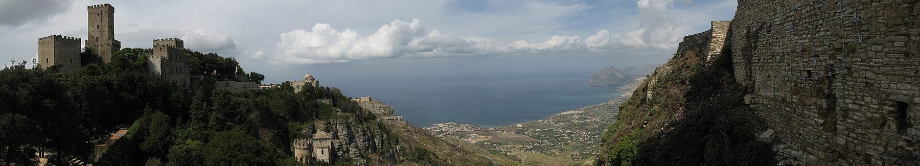 Ein weiter Panoramablick auf Erice von oben, mit Terrakottadächern und dem Bogen der sizilianischen Küste.