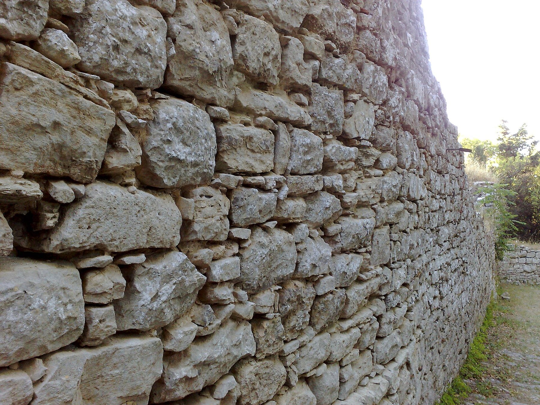 Ein Abschnitt der antiken elymisch-punischen Stadtmauern von Erice mit den unregelmäßigen megalithischen Blöcken an der Basis.